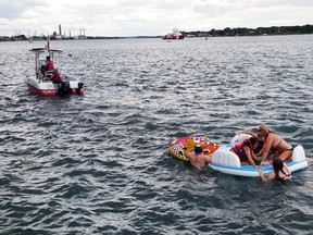 A Canadian Coast Guard rescue vessel assists floaters in need of rescuing on the St. Clair River Sunday August 21 2016.  There were involved in the Port Huron Float Down, an event that has no official organizer and poses significant and unusual hazards given the fast-moving current, large number of participants, lack of life jackets, and, as was the case this year, challenging weather conditions.  Approximately 1,500 U.S. residents involved in the float down ended up  in Sarnia Sunday, and had to be sent by bus back to Michigan.
Photo courtesy of the Canadian Coast Guard. 

Handout/Sarnia Observer/Postmedia Network