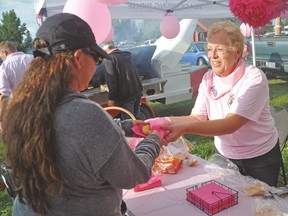 Jan Fraser serves up a burger bun with a pink napkin Thursday during the visit of the Wild Pink Yonder riders. Stephen Tipper Vulcan Advocate