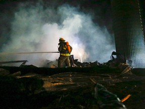 Luke Hendry/Intelligencer file photo 
Quinte West firefighter John Briscoe sprays water on hotspots during a barn fire in Quinte West in October 2014. The fire on a farm just outside the village of Stirling destroyed the barn but there were no injuries to people or animals.