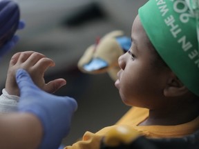 In this undated handout photo provided by the Children's Hospital of Philadelphia in Pennsylvania, a nurse checks the newly tranplanted hands of 8-year-old Zion Harvey of Baltimore, Maryland. (AFP PHOTO/HANDOUT/CHILDRENS HOSPITAL OF PHILADELPHIA)