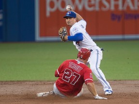 Los Angeles Angels' Mike Trout is forced out at second base as Toronto Blue Jays' Darwin Barney throws to first base to complete the double play during a game in Toronto on Aug. 23, 2016. (THE CANADIAN PRESS/Chris Young)