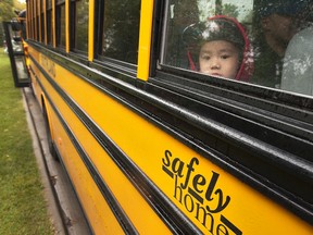 Hugo Wu, 5, peers out of a school bus window during an event at Northlands by The First Rider program in Edmonton August 23, 2016.  Dan Riedlhuber / Postmedia