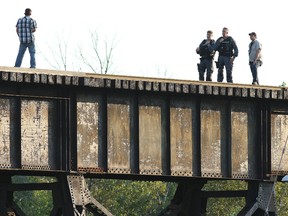 Officers with the Greater Sudbury Police Service talk to a distraught man during a standoff on the Beatty Street trestle in Sudbury, Ont. on Tuesday August 23, 2016. Gino Donato/Sudbury Star/Postmedia Network