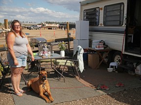 Susan McKay and her dog, Chaz, outside her camper at a temporary campsite in Abraham's Land on August 23, 2016. Olivia Condon/Fort McMurray Today/Postmedia Network