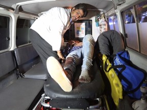 A wounded person is treated in an ambulance after an attack on the campus of the American University in the Afghan capital Kabul on Wednesday, Aug. 24, 2016. (AP Photo/Rahmat Gul)