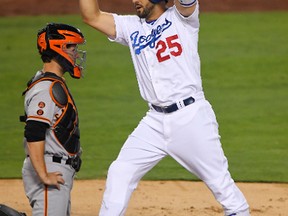 Dodgers' Rob Segedin celebrates after scoring on a solo home run, as Giants catcher Buster Posey kneels at the plate during second inning MLB action in Los Angeles on Tuesday, Aug. 23, 2016. (Mark J. Terrill/AP Photo)