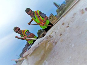 Cody Millian and Wayne Walker of ASAP Secured try their hands at the salt block by the History Tent during the weekend's Salt Festival. (Bethany Davidson/Special to the Signal Star)