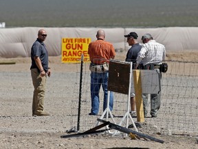 This Aug. 27, 2014 file photo shows people seen at the Last Stop outdoor shooting range in White Hills, Ariz. The family of an Arizona shooting range instructor who was accidentally killed by a 9-year-old girl with an Uzi is suing the business. The suit seeks a jury trial to determine damages for Charles Vacca's widow and three children as well as his ex-wife and mother. It says the owners and operators of the Last Stop shooting range were negligent in Vacca's August, 2014 death. (AP Photo/John Locher, File)