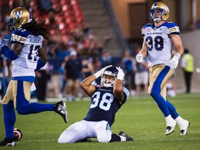 Toronto Argonauts fullback Declan Cross (38) reacts after missing a catch as Winnipeg Blue Bombers defensive back CJ Roberts (17) and Blue Bombers linebacker Ian Wild (38) look on during second half CFL football action in Toronto on Friday, August 12, 2016. THE CANADIAN PRESS/Nathan Denette