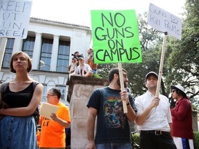 Students holds signs and sex toys as they protest a campus carry law in Austin, Texas, Wednesday Aug. 24, 2016. Hundreds of University of Texas students waved sex toys at a campus rally during the first day of classes, protesting a new state law that allows concealed handguns in college classrooms, buildings and dorms. (AP Photo/John Mone)