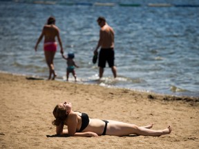 Amanda Bertrand-Noel soaks in the hot sun at Mooney's Bay beach Saturday.   Ashley Fraser/ Postmedia