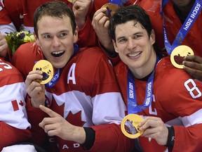 Jonathan Toews (left) and Sidney Crosby pose with their gold medals at the end of the Sochi Olympics. On Thursday, Toews was named an alternate captain for Canada's World Cup team, with Crosby named captain. (AFP FILE PHOTO/JONATHAN NACKSTRAND)