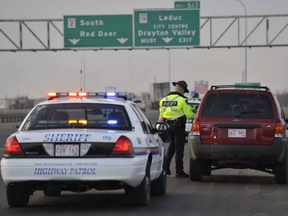 An Alberta Highway Patrol Sheriff hands out a speeding ticket to a motorist on Queen Elizabeth II Highway south of Edmonton.
