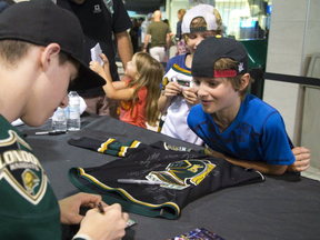 Mitch Marner signs for Aiden Ward,(right) and his twin brother Connor, (rear) as the Knights had a huge autograph session at Budweiser Gardens as part of the Knights parade in London, Ont. on Thursday August 25, 2016. Mike Hensen/The London Free Press/Postmedia Network