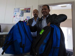 Syrian refugee Mohad El-Mohamad picks up backpacks Thursday for his four sons and one daughter at the Salvation Army Crossroads Community Church. It gave out more than 700 new backpacks filled with school supplies for children in need. Greg  Southam / Postmedia