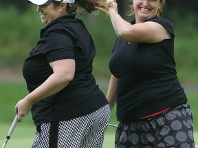 Erin and Morgan McHardy celebrate after making a putt during the Ottawa Sun Scramble at eQuinelle Golf Club.  (Tony Caldwell, Ottawa Sun)