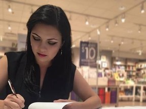 Chelsey Krause signs a copy of her new novel All Shook Up at Indigospirit in Westland Market Mall on Aug. 13. - Photo submitted