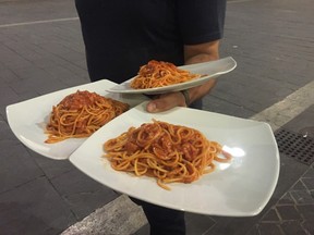 Waiter Andrea Orsini serves pasta all'amatriciana at a restaurant in Ascoli Piceno, Italy, Friday, Aug. 26, 2016. Food lovers and chefs in Italy and beyond are urging restaurants to serve up more pasta all’amatriciana in a move to support the quake-hit hometown of the hearty dish. The rustic food, made of tomato sauce with pork jowl and topped with pecorino cheese, comes from Amatrice, which was destroyed by this week’s earthquake and the idea is for some of the proceeds to go to help the devastated areas rebuild.