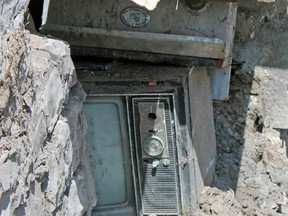 Construction workers on Montreal Street in Kingston made the perplexing discovery on Thursday of an old television set, a deep fryer and an air conditioning device stacked on top of each other under the sidewalk. The objects haven't yet been fully removed from the site. (Victoria Gibson/For The Whig Standard)