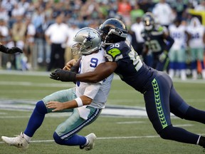 Cowboys quarterback Tony Romo (left) is tackled by Seahawks defensive end Cliff Avril during NFL preseason action in Seattle on Thursday, Aug. 25, 2016. (Elaine Thompson/AP Photo)