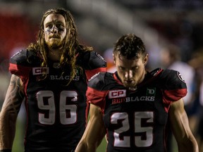 Redblacks defensive lineman Aaron Karlen (left) and fullback Brendan Gillanders leave the field after a loss to the B.C. Lions. (Errol McGihon, Ottawa Sun)