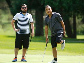 Ken Lee (right) and playing partner Nick Burden eye a putt during the Ottawa Sun Scramble at Outaouais Golf Club. (Patrick Doyle, Postmedia Network)