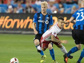 Toronto FC’s Sebastian Giovinco is taken down by a Montreal Impact defender during last night’s game. Giovinco would leave in the second half with an injury. (THE CANADIAN PRESS)