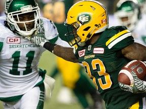 Edmonton Eskimos running back Shakir Bell, right, tries to fight off Saskatchewan Roughriders Ed Gainey during second half CFL action at Commonwealth Stadium, in Edmonton on Friday Aug. 26, 2016. Bell received a face mask penalty on the play.