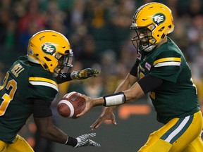 Edmonton Eskimos' quarterback Mike Reilly (13) hands off to Shakir Bell (33) during second half CFL action against the Saskatchewan Roughriders at Commonwealth Stadium, in Edmonton on Friday Aug. 26, 2016.