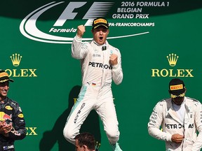 Mercedes AMG Petronas F1 Team's German driver Nico Rosberg (C) celebrates winning next to second placed Red Bull Racing's Australian driver Daniel Ricciardo and third placed Mercedes AMG Petronas F1 Team's British driver Lewis Hamilton after the Belgian Formula One Grand Prix at the Spa-Francorchamps circuit in Spa on Aug. 28, 2016. (JOHN THYS/AFP/Getty Images)
