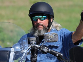 A rider waves as he drives by during the annual Quinte Ride For Paws motorcycle ride on Sunday August 28, 2016 in Trenton, Ont. Tim Miller/Belleville Intelligencer/Postmedia Network