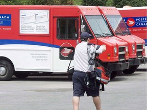 A postal worker walks past Canada Post trucks at a sorting centre in Montreal, Friday, July 8, 2016.THE CANADIAN PRESS/Ryan Remiorz