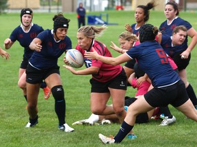 Michelle Mosher, middle, of the Grande Prairie Sirens, tries to run through oncoming tackles against the Edmonton Clanswomen in Edmonton Rugby Union Division I female play on Saturday August 27, 2016 at Macklin Field in Grande Prairie, Alta. The Clanswomen won 39-0.
Logan Clow/Grande Prairie Daily Herald-Tribune/Postmedia Network