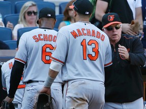 Baltimore Orioles manager Buck Showalter greets second baseman Jonathan Schoop and third baseman Manny Machado after a game against the New York Yankees on Aug. 28, 2016. (AP Photo/Kathy Willens)