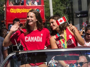Olympian Penny Oleksiak, left, and fellow swim team member, Michelle Williams, are pictured in Sunday's Olympic celebration parade in the Beach. (CRAIG ROBERTSON, Toronto Sun)