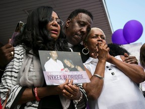 Family members and supporters hug Diann Aldridge during a vigil for her daughter Nykea Aldridge at the Willie Mae Morris Empowerment Center, Sunday afternoon, Aug. 28, 2016, in Chicago. Aldridge, a 32-year-old mother of four, and the cousin of NBA star Dwyane Wade, was pushing her baby in a stroller near a school where she'd planned to register her children when she was shot in the head and arm. She wasn't the intended target, Cmdr. Brendan Deenihan said at a news conference Sunday, but rather a driver who had just dropped off passengers in the neighborhood.  (Ashlee Rezin/Chicago Sun-Times via AP)