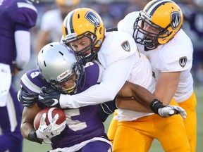 Alex Taylor of the Western Mustangs is tackled by Erik Lovis and Austin Thornton of the Windsor Lancers during their Ontario university football season-opener Sunday night at TD Stadium. The Mustangs won 78-6. (MIKE HENSEN, The London Free Press)