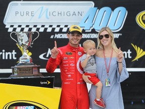 Kyle Larson, driver of the #42 Target Chevrolet, girlfriend Katelyn Sweet and son Owen Larson celebrate in Victory Lane after winning the NASCAR Sprint Cup Series Pure Michigan 400 at Michigan International Speedway on Aug. 28, 2016. (Dylan Buell/Getty Images)