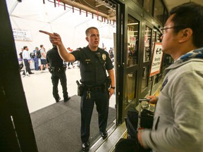 A police officer directs a passenger at Terminal 7 in Los Angeles International Airport, Sunday, Aug. 28, 2016. Reports of a gunman opening fire that turned out to be false caused panicked evacuations at Los Angeles International Airport on Sunday night, while flights to and from the airport saw major delays. Passengers who fled had to be rescreened through security. A search through terminals brought no evidence of a gunman or shots fired, Los Angeles police spokesman Andy Neiman said. (AP Photo/Ringo H.W. Chiu)