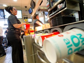 McDonald's manager Ashley Catala, who has been in management with the company for five years, helps pack happy meals at the restaurant located at Highbury Avenue and Hamilton Road, in London, Ont. on Friday August 19, 2016. (CRAIG GLOVER, The London Free Press)