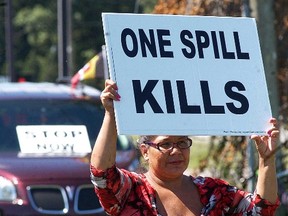 Walpole Island's Becky Blackbird holds up a sign during a gathering of people who were protesting a Union Gas pipeline on Monday, August 29, 2016. Construction was supposed to start on Monday, but was cancelled due to a blockade at the Walpole Island Bridge. (DAVID GOUGH/Postmedia Network)