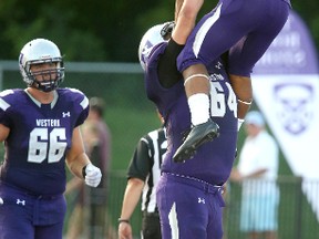Alex Taylor gets a bit of a lift from 6-foot-7 Sean Jamieson after scoring Western?s first touchdown against Windsor on Sunday. (MIKE HENSEN, The London Free Press)