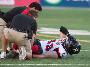 Medical personnel attend to Ottawa Redblacks linebacker Olivier Goulet-Veilleux as he lies injured during second quarter CFL football action against the Montreal Alouettes, in Montreal on June 30, 2016. (THE CANADIAN PRESS/Paul Chiasson)