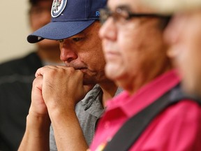 Norway House resident Leon Swanson weeps at a press conference last week, where Manitoba's former aboriginal affairs minister Eric Robinson, centre, announced Swanson and David Tait Jr., right, were switched at birth in 1975 when their mothers gave birth at Norway House Indian Hospital. (THE CANADIAN PRESS/John Woods)