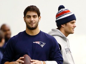 Patriots backup QB Jimmy Garoppolo (left) holds a football as starting QB Tom Brady (right) stands by during a walkthrough at the team's facility in Foxborough, Mass., on Jan. 23, 2015. Brady will have to sit out the first four games of this season for his role in the "Deflategate" scandal. Garoppolo will start in Brady's absence. (AP Photo/Elise Amendola/Files)