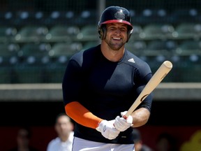 Former NFL quarterback Tim Tebow smiles during a workout for baseball scouts and the media during a showcase on the campus of the University of Southern California, Aug. 30, 2016. (AP Photo/Chris Carlson)