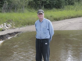 Woodlands County resident and former county councilllor Daryl Yagos stands next to the low-level crossing just north of his home on Aug. 23. Due to high rain levels, the crossing was flooded over, as happens a couple of times every year. Yagos has been pushing the county for several years for a permanent solution to the crossing being flooded.