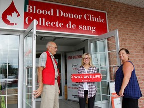 Canadian Blood Services has issued an urgent call for 32,000 units to be collected nationally by Labour Day to help offset the summer collection shortfalls. Long-time volunteer Tony Dancy, first-time donor Bronwyn Riha and territory manager Debi Barfoot hold the doors open for new donors at the Canadian Blood Services Kingston Region permanent clinic at 850 Gardiners Rd. in Kingston. (Julia McKay/The Whig-Standard)