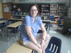 Liane Penny, a new teacher at Kingston Collegiate and Vocational Institute, sits in her classroom at the school in Kingston on Wednesday. (Michael Lea/The Whig-Standard)