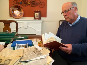 Dennis Alsop Jr. pages through a treasure trove of notes and clippings gathered by his father, a retired OPP Supt. Dennis Alsop. (Free Press file photo)